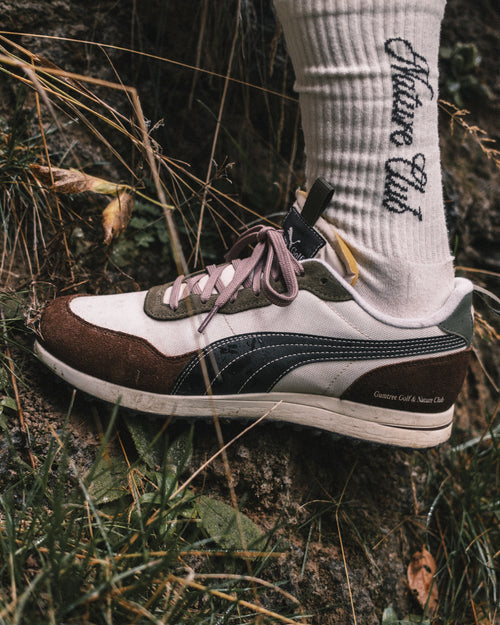 Sneaker with a nature club sock on grass