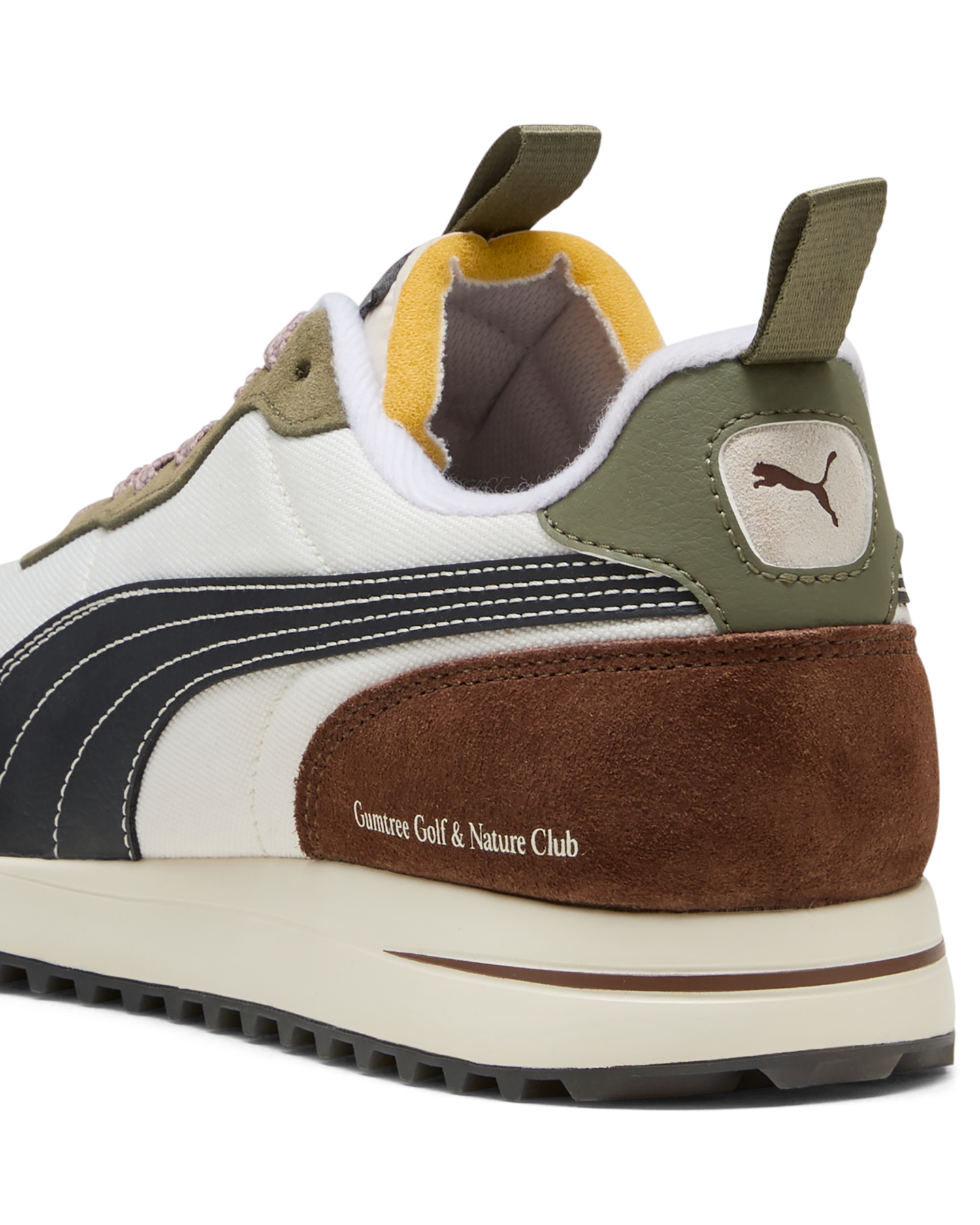 Close-up of a Puma sneaker with brown, white, and green color scheme on a white background