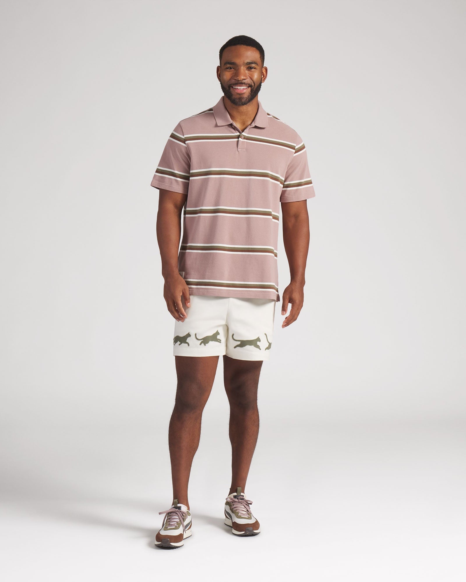 Man wearing a striped polo shirt and shorts on a white background