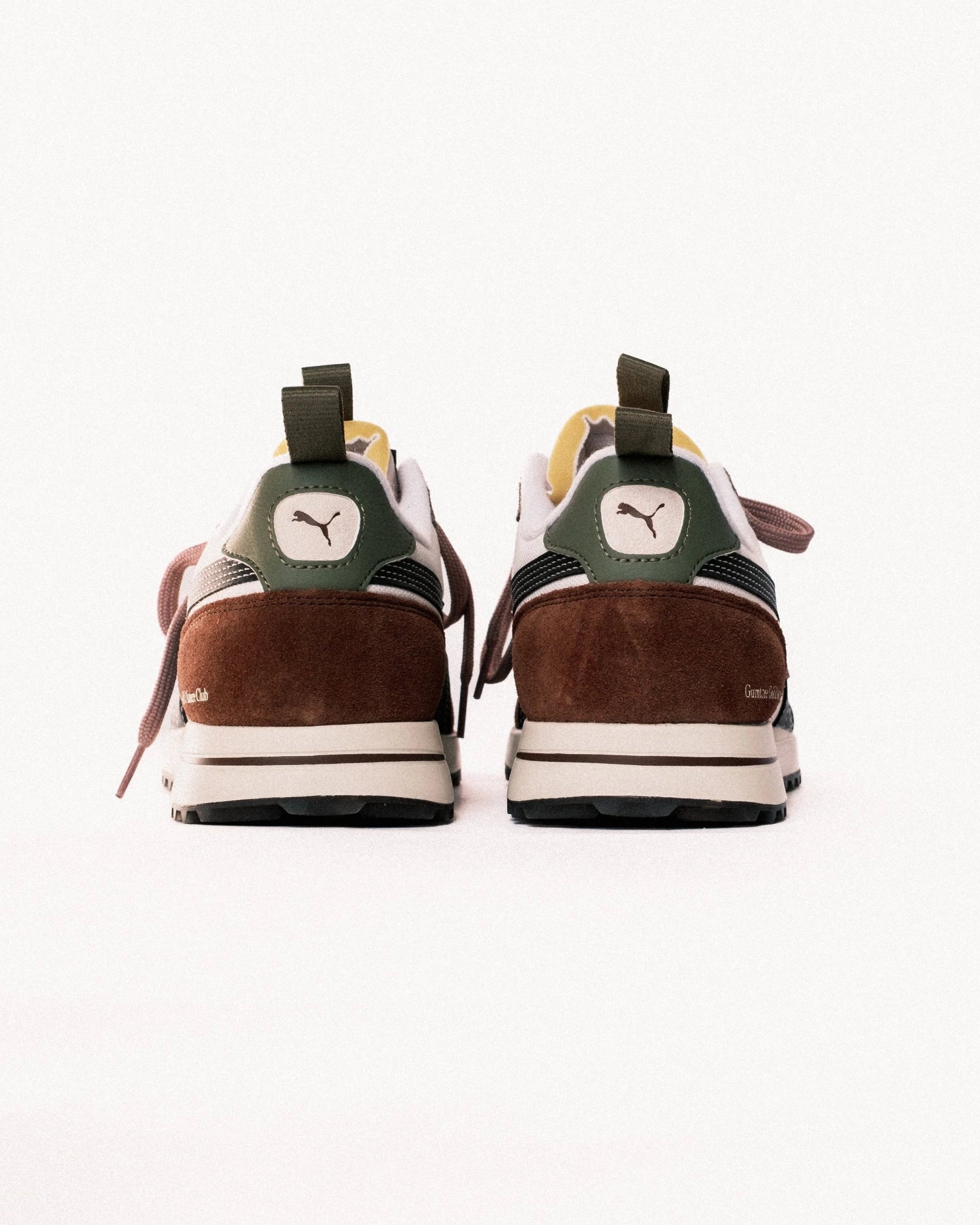 Pair of brown and green sneakers with a visible brand logo on a white background