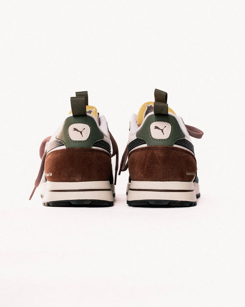 Pair of brown and green sneakers with a visible brand logo on a white background