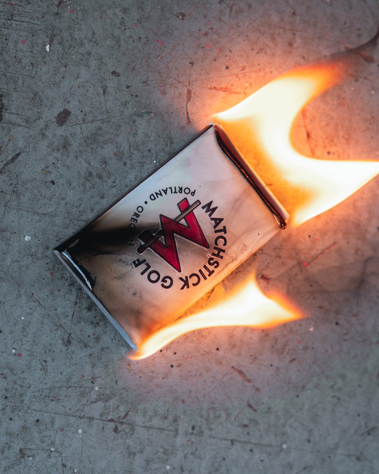 Flaming matchbox on a concrete surface