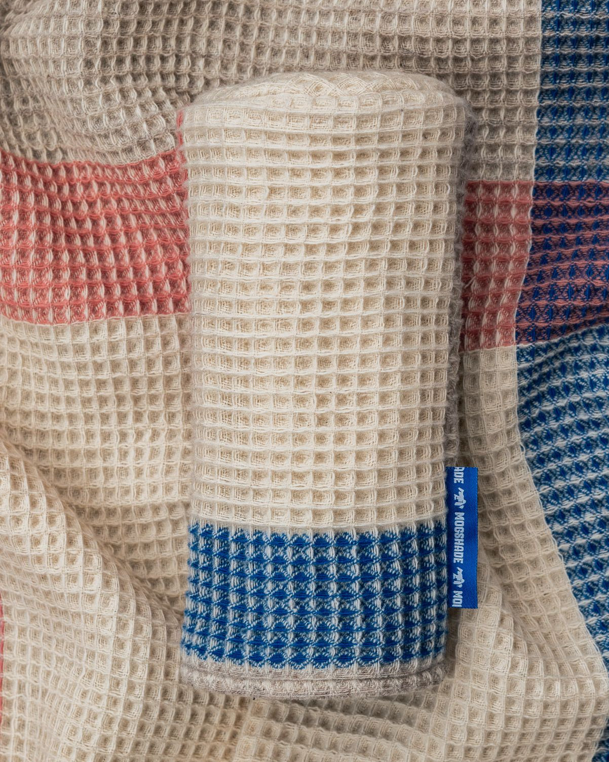 Textured fabric with a cylindrical object and a visible brand label.