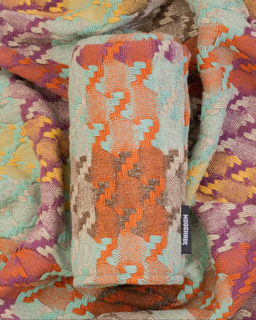 Stack of colorful patterned fabric with a visible brand label.
